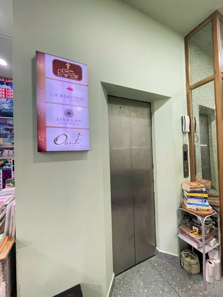 Sign in front of the lift at 79 Pasteur showing Linh Lan on L2